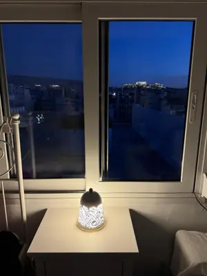 a vase sitting on a table in front of a window at Krezias Apartments K1 Acropolis View & Jacuzzi ! in Athens
