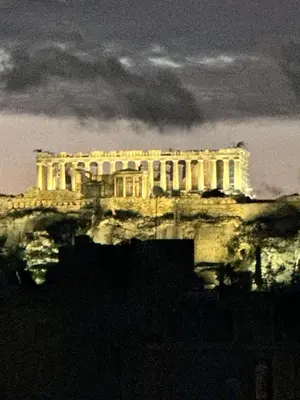 a building on top of a hill at night at Krezias Apartments K1 Acropolis View & Jacuzzi ! in Athens