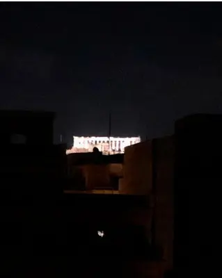 a white bus is lit up in the dark at Krezias Apartments ST5 Acropolis View ! in Athens