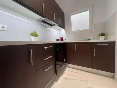 a kitchen with brown cabinets and a window at Krezias Apartments ST5 Acropolis View ! in Athens