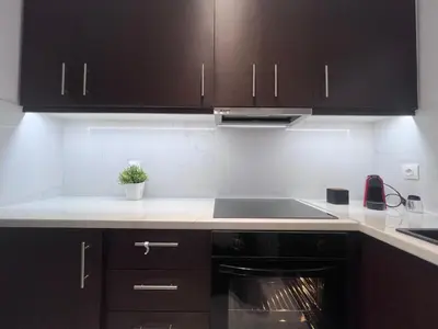 a kitchen with black cabinets and a stove top oven at Krezias Apartments ST5 Acropolis View ! in Athens