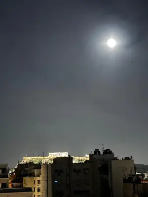 a view of the moon over a city at Krezias Apartments ST5 Acropolis View ! in Athens