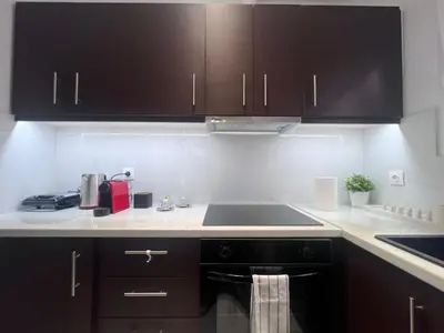 a kitchen with black cabinets and a sink at Krezias Apartments ST5 Acropolis View ! in Athens
