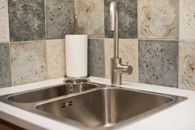 a stainless steel sink with a roll of paper towels at Alex Guesthouse Stylish Studio near the Sea in Piraeus