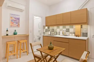 a kitchen with a table and chairs and a kitchen with a sink at Alex Guesthouse Stylish Studio near the Sea in Piraeus