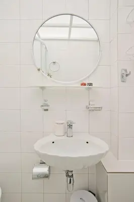 a white bathroom with a sink and a mirror at Alex Guesthouse Stylish Studio near the Sea in Piraeus