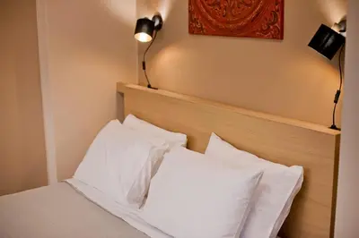 a bed with two white pillows and a lamp at Alex Guesthouse Stylish Studio near the Sea in Piraeus