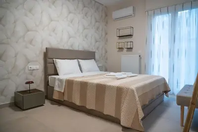 a bedroom with a bed with white sheets and a window at Elegant Athenian Escape near Lycabettus in Athens