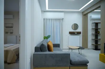 a living room with a blue couch and a bed at Elegant Athenian Escape near Lycabettus in Athens
