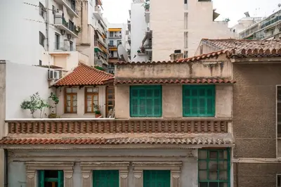 an old building with green windows in a city at Elegant Athenian Escape near Lycabettus in Athens