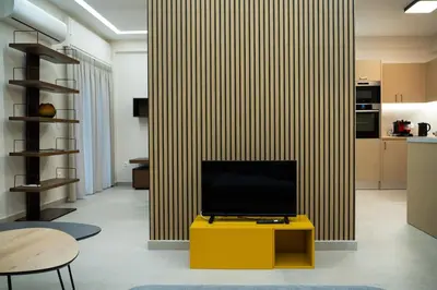 a living room with a television on a yellow table at Elegant Athenian Escape near Lycabettus in Athens