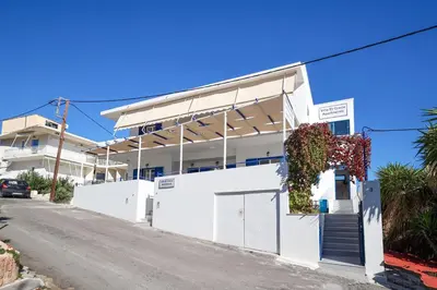 a white building on the side of a street at Villa El Greco Apartments in Agia Marina Aegina