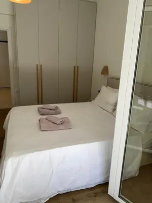 a bedroom with a white bed with towels on it at Beach side Marina Alimos apartment in Athens