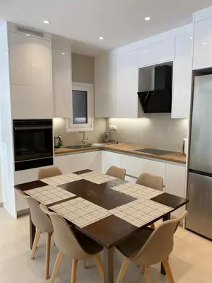 a kitchen with a table and chairs in a kitchen at Beach side Marina Alimos apartment in Athens