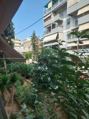 a garden in front of a building at Beach side Marina Alimos apartment in Athens
