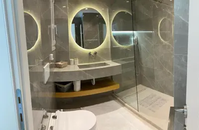 a bathroom with a sink and a glass shower at Beach side Marina Alimos apartment in Athens