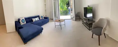 a living room with a blue couch and a tv at Beach side Marina Alimos apartment in Athens
