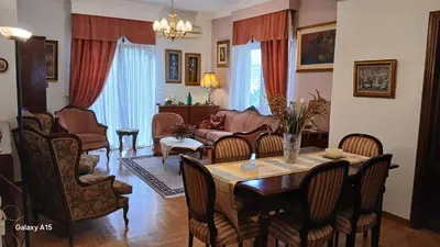 a living room with a table and chairs and a couch at Cozy Classic Residence 