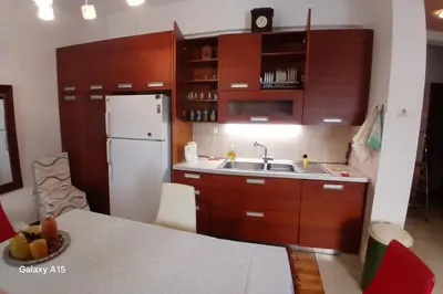 a kitchen with wooden cabinets and a white refrigerator at Cozy Classic Residence 