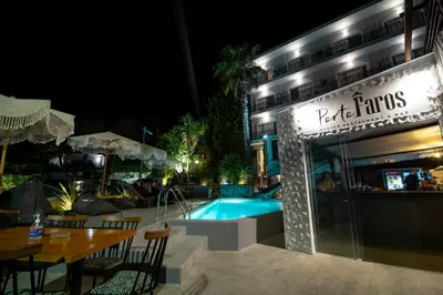 a restaurant with a swimming pool at night at Kiani Akti in Porto Rafti
