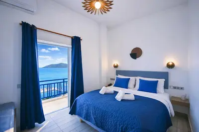 a bedroom with a bed and a view of the ocean at Kiani Akti in Porto Rafti