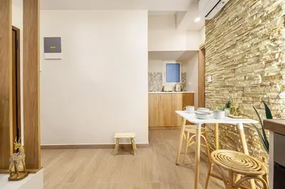 a kitchen with a table and a stone wall at Athens Lodge in Koukaki in Athens