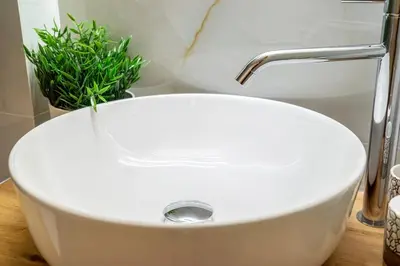 a white sink in a bathroom with a plant at Athens Lodge in Koukaki in Athens