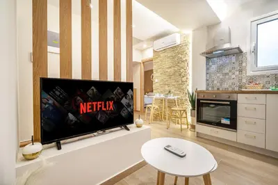 a living room with a flat screen tv on a wall at Athens Lodge in Koukaki in Athens