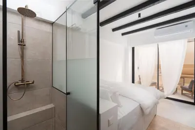 a bedroom with a glass shower and a bed at 1BR Backyard Jacuzzi Retreat Near Acropolis in Athens