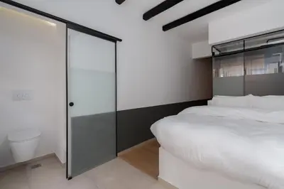a bedroom with a white bed and a glass wall at 1BR Backyard Jacuzzi Retreat Near Acropolis in Athens