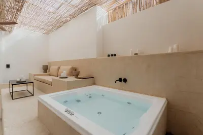 a large bath tub in a room with a couch at 1BR Backyard Jacuzzi Retreat Near Acropolis in Athens