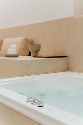 a jacuzzi tub in a room with a chair at 1BR Backyard Jacuzzi Retreat Near Acropolis in Athens