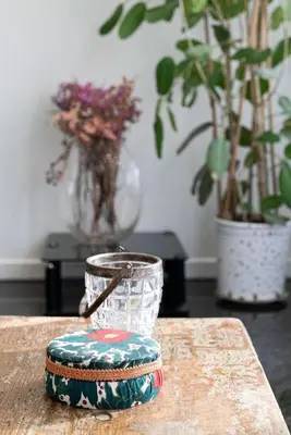 a table with a candle and a vase with plants at Spacious & Artistic Retro 2BD Apt with SAUNA in Athens