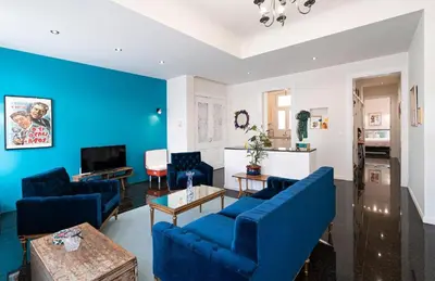 a living room with blue furniture and a blue wall at Spacious & Artistic Retro 2BD Apt with SAUNA in Athens