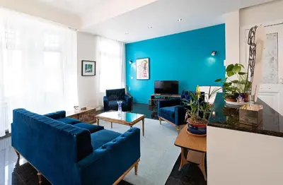 a living room with blue walls and blue furniture at Spacious & Artistic Retro 2BD Apt with SAUNA in Athens