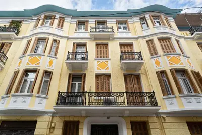 a large yellow building with windows and balconies at Spacious & Artistic Retro 2BD Apt with SAUNA in Athens