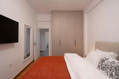 a bedroom with a bed and a flat screen tv at Cozy & Stylish 2BR Home Near Kallimarmaro in Athens