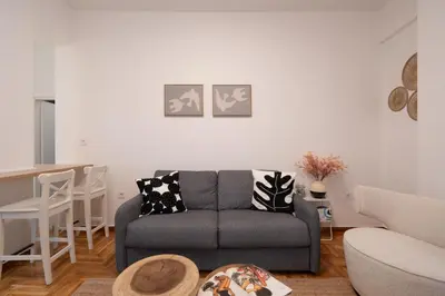 a living room with a couch and a table at Cozy & Stylish 2BR Home Near Kallimarmaro in Athens