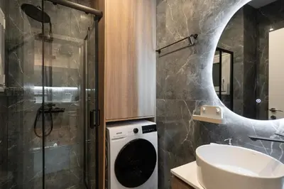 a bathroom with a sink and a washing machine at Cozy & Stylish 2BR Home Near Kallimarmaro in Athens