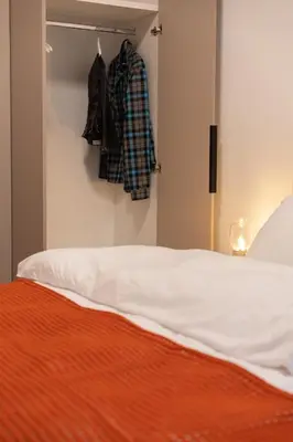 a bedroom with a bed with an orange blanket at Cozy & Stylish 2BR Home Near Kallimarmaro in Athens