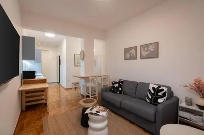 a living room with a couch and a kitchen at Cozy & Stylish 2BR Home Near Kallimarmaro in Athens