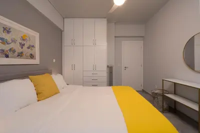 a bedroom with a large white bed with a yellow blanket at Elegant 2BR Apt Near Acropolis & Metro in Athens