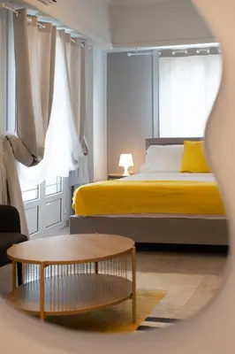 a bedroom with a yellow bed and a table at Elegant 2BR Apt Near Acropolis & Metro in Athens