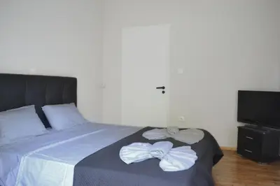 a bedroom with a bed with two white bows on it at Alice's Apartment - Athens, Ελλάδα in Athens