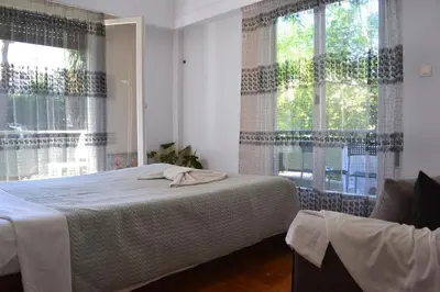 a bedroom with a bed and a large window at Alice's Apartment - Athens, Ελλάδα in Athens