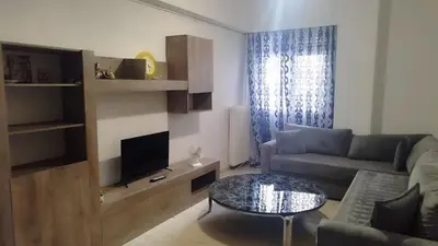 a living room with a couch and a table at Kallithea Athens Star in Athens