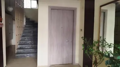 a wooden door in a hallway with stairs at Kallithea Athens Star in Athens
