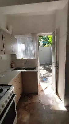 a kitchen with a sink and an open door at Kallithea Athens Star in Athens