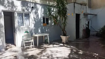 a house with a table and a chair and a palm tree at Kallithea Athens Star in Athens