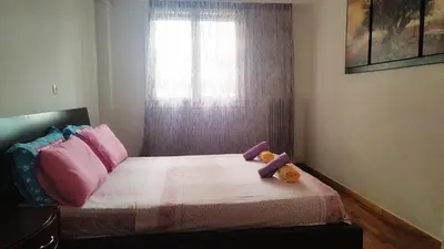 a bedroom with a bed with pink pillows and a window at Kallithea Athens Star in Athens